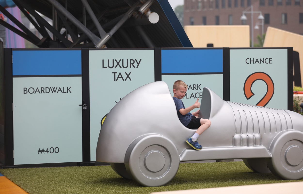 A little boy in a Monopoly car.