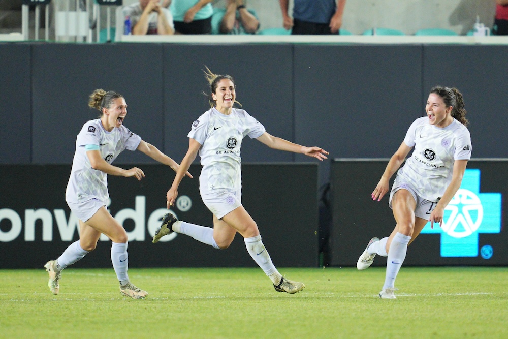 Savannah DeMelo runs to celebrates with teammates after tying a game