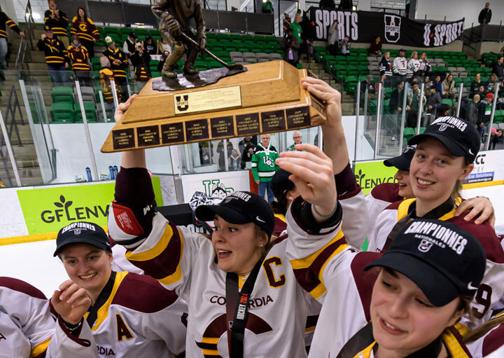 Concordia University teammates celebrate U SPORTS championship by hoisting trophy