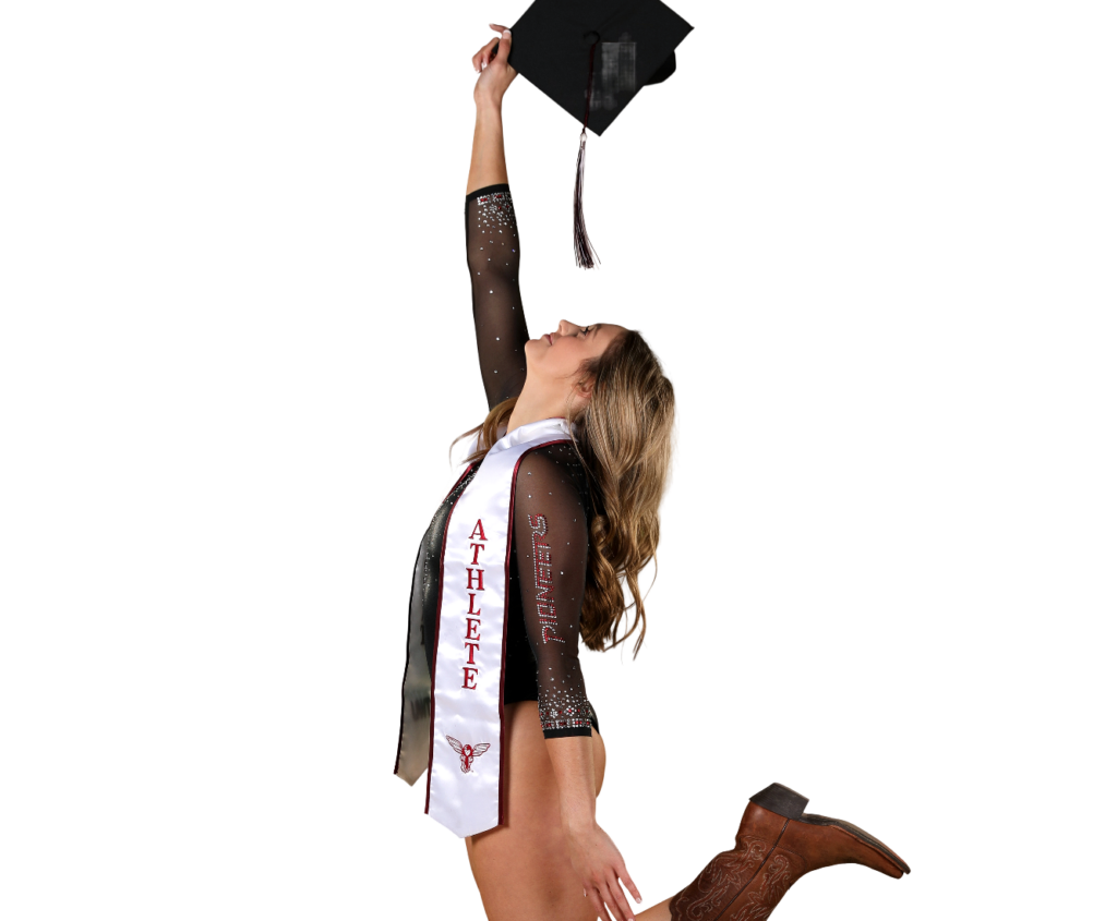 A gymnast in a leotard, sash, and mortarboard poses for a graduation photo.