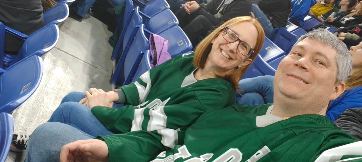 A selfie of Wayne (right) and Kerry (left) wearing green PWHL Boston jersyes at the Tsongas Center.