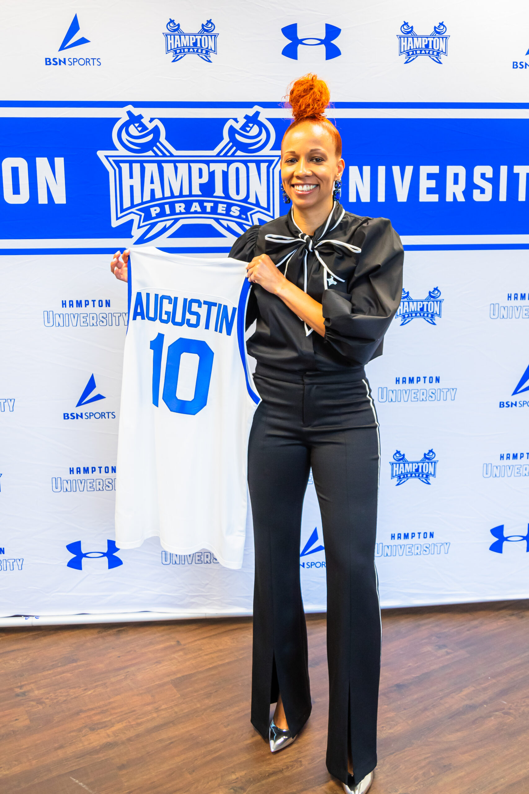 Tamisha Augustin holds up a No. 10 Hampton jersey with her last name on it.