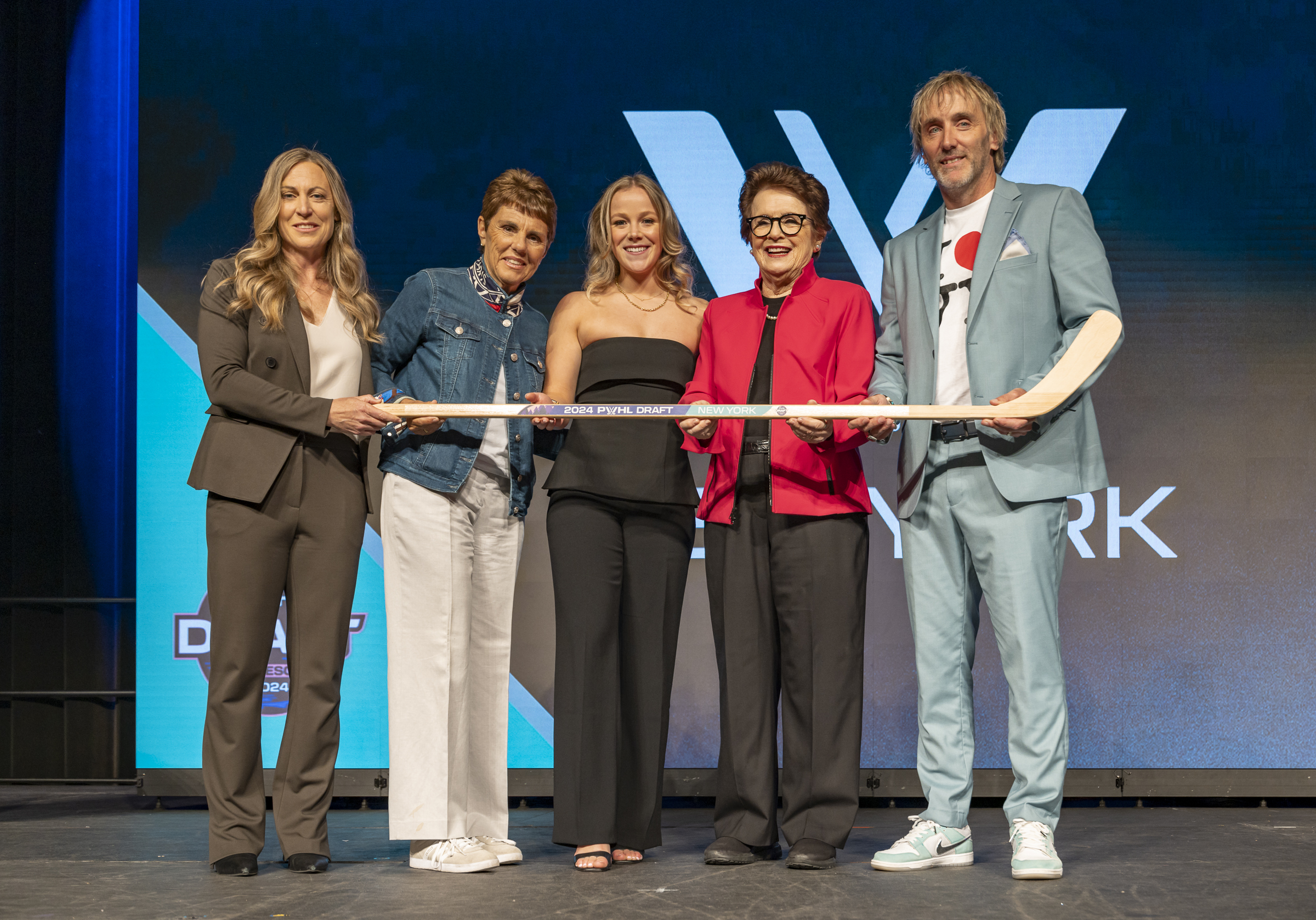 Sarah Fillier stands on the PWHL draft stage with league officials and the New York general manager.