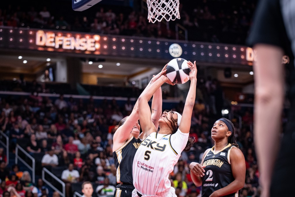Sky forward Angel Reese attempts to get a shot off against Mystics center Stef Dolson