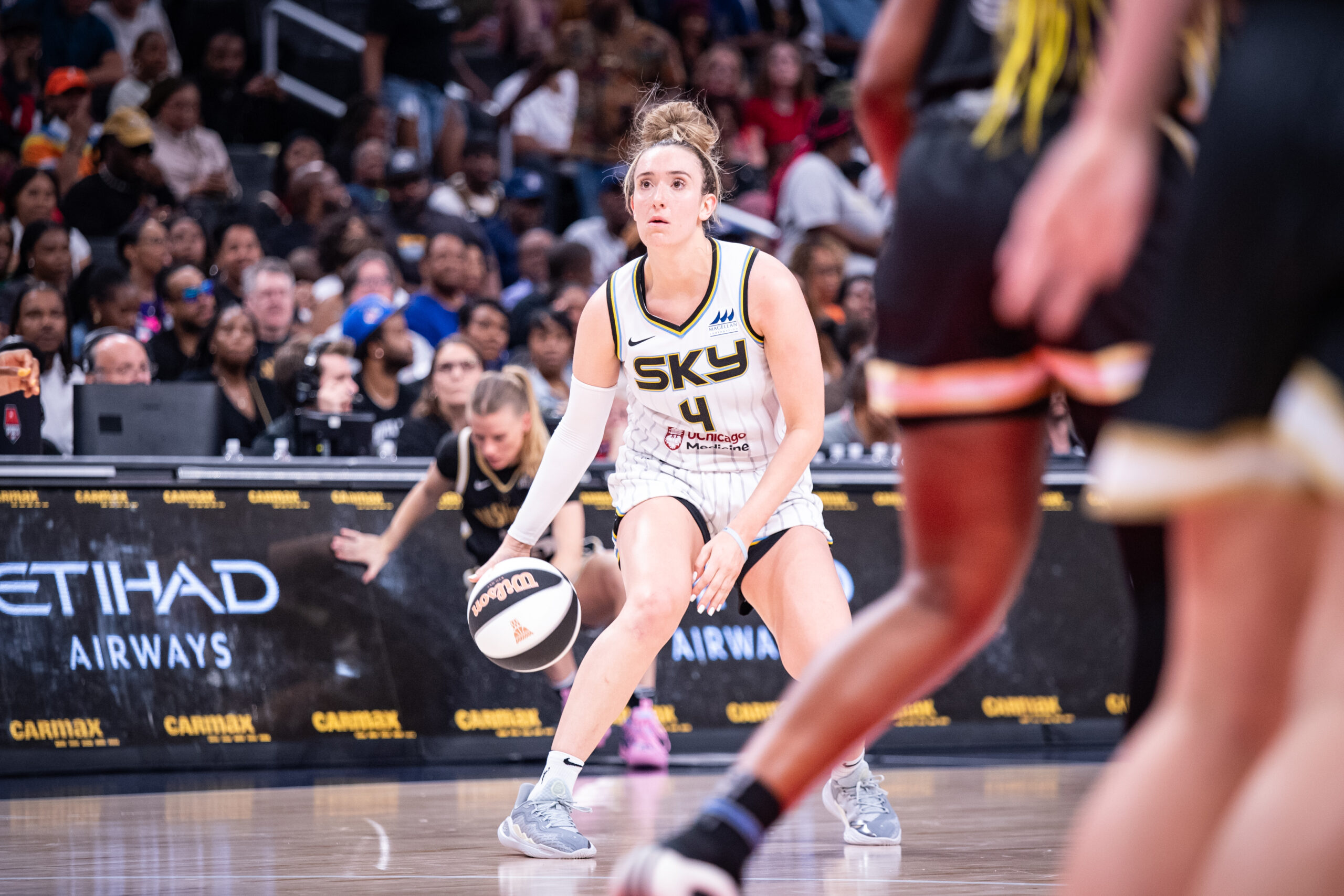 Chicago Sky guard Marina Mabrey dribbles between her legs while looking at the hoop.