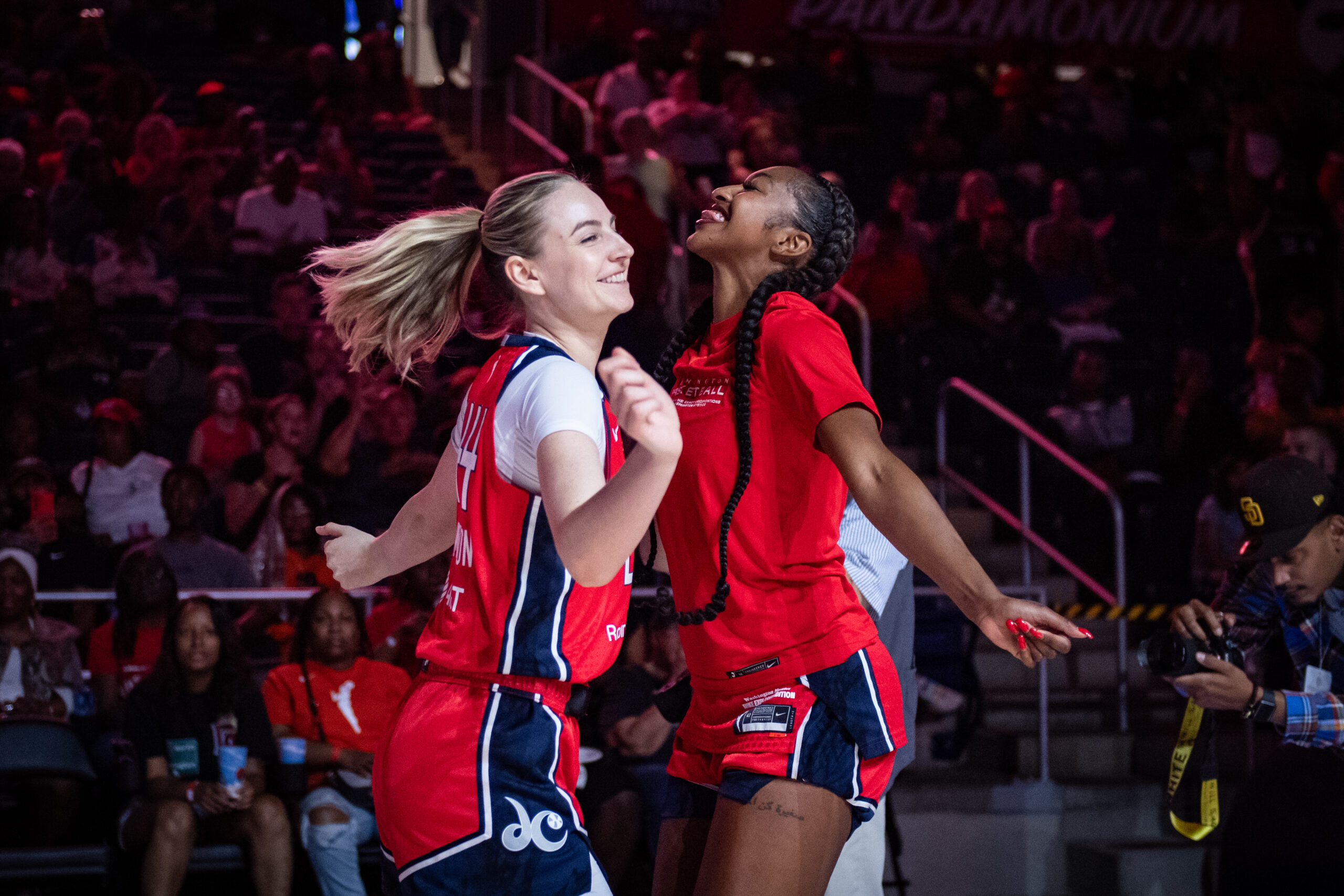 Washington Mystics wings DiDi Richards and Karlie Samuelson face each other. They smile and shimmy, and Richards sticks her tongue out.