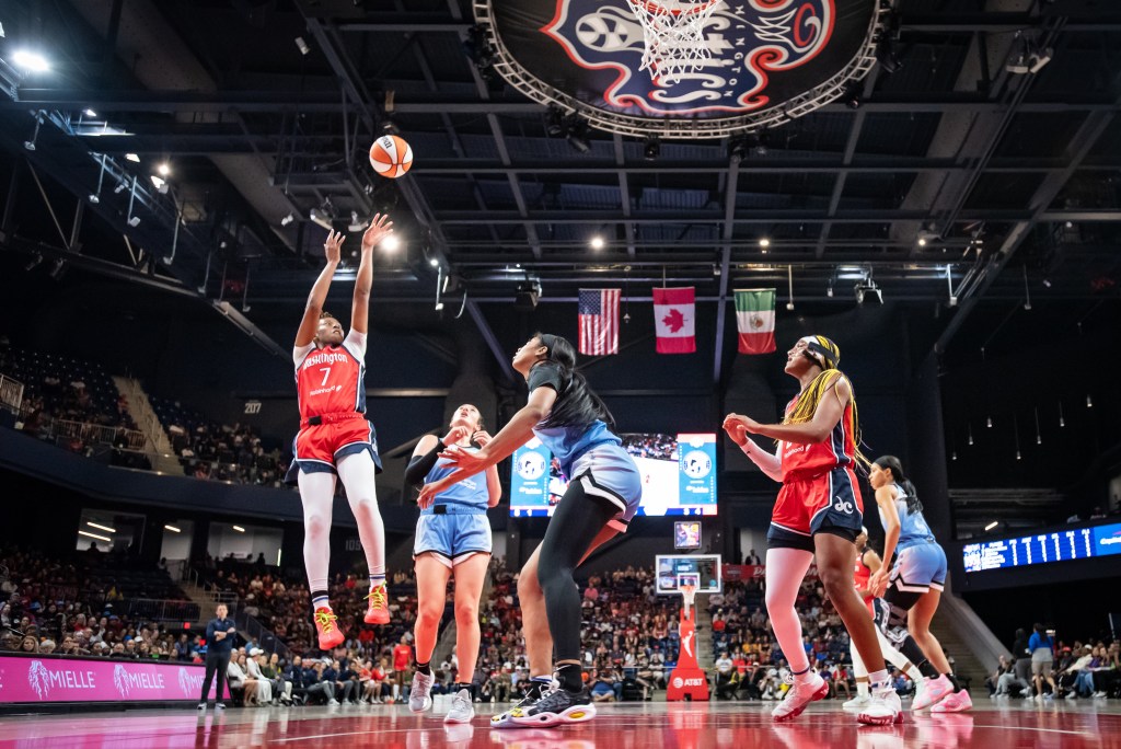 Washington Mystics guard Ariel Atkins shoots an open jump shot in the paint as a Chicago Sky defender arrives too late to contest it.