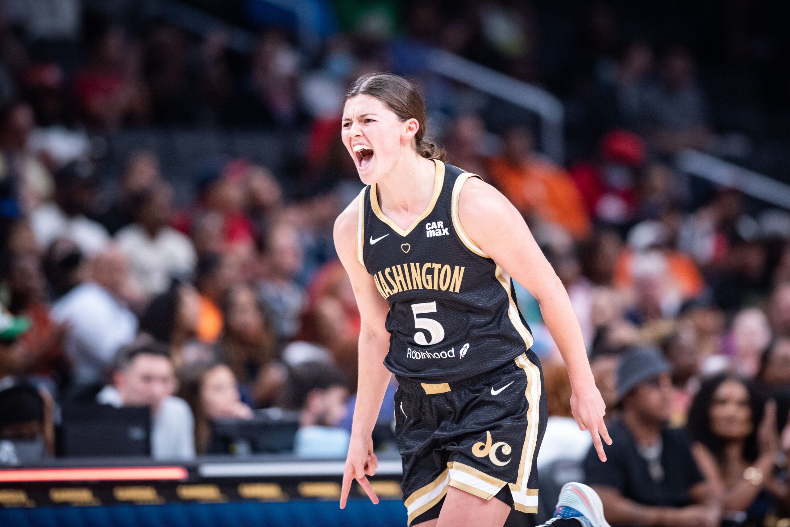 Washington Mystics point guard Jade Melbourne yells in celebration after two quick 2-pointers. She points two fingers on each hand down at the ground.