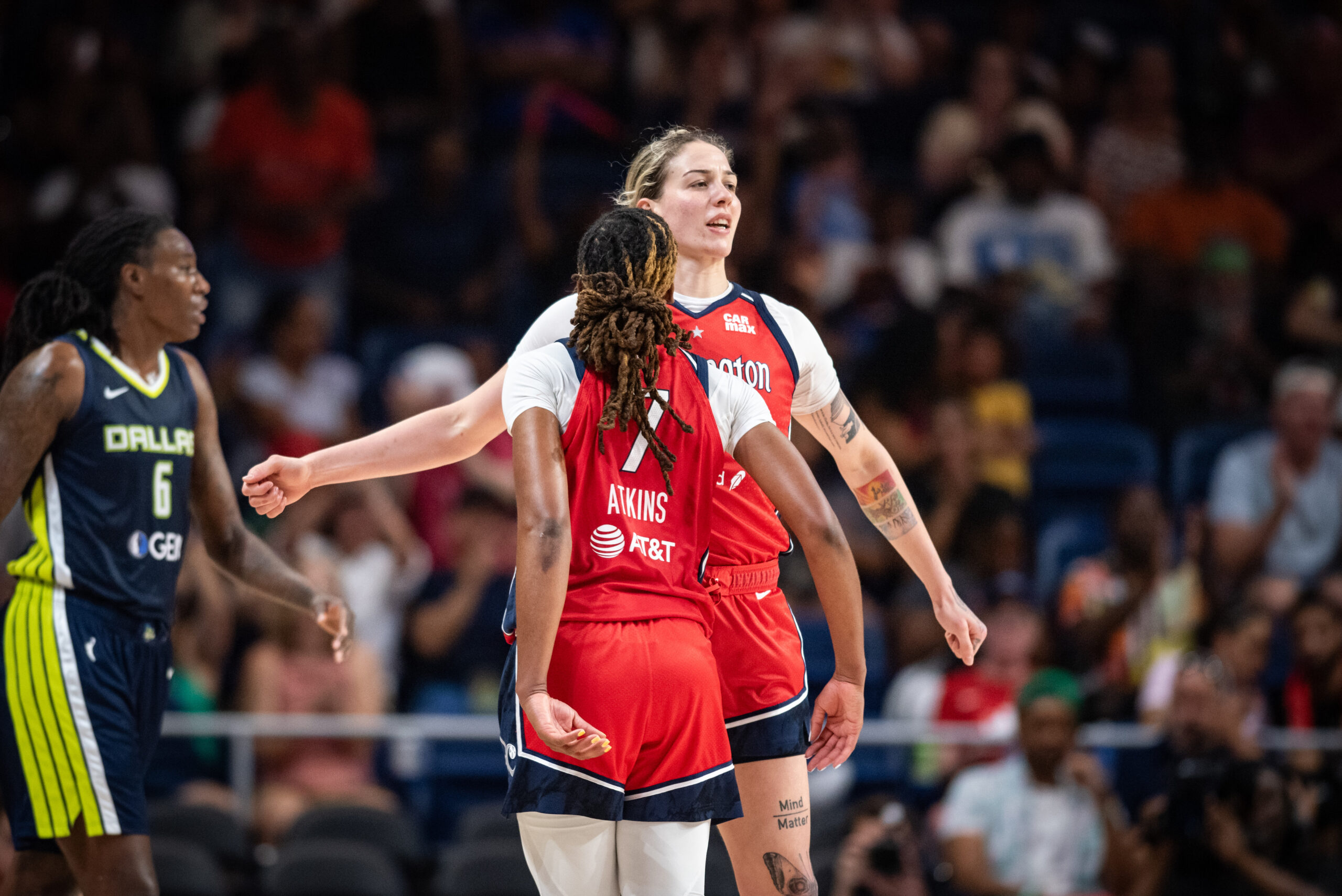 Washington Mystics guard Ariel Atkins is shown from behind as she chest bumps forward Emily Engstler.