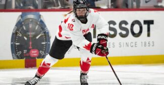 Hockey player Sarah Fillier handles the puck on the ice