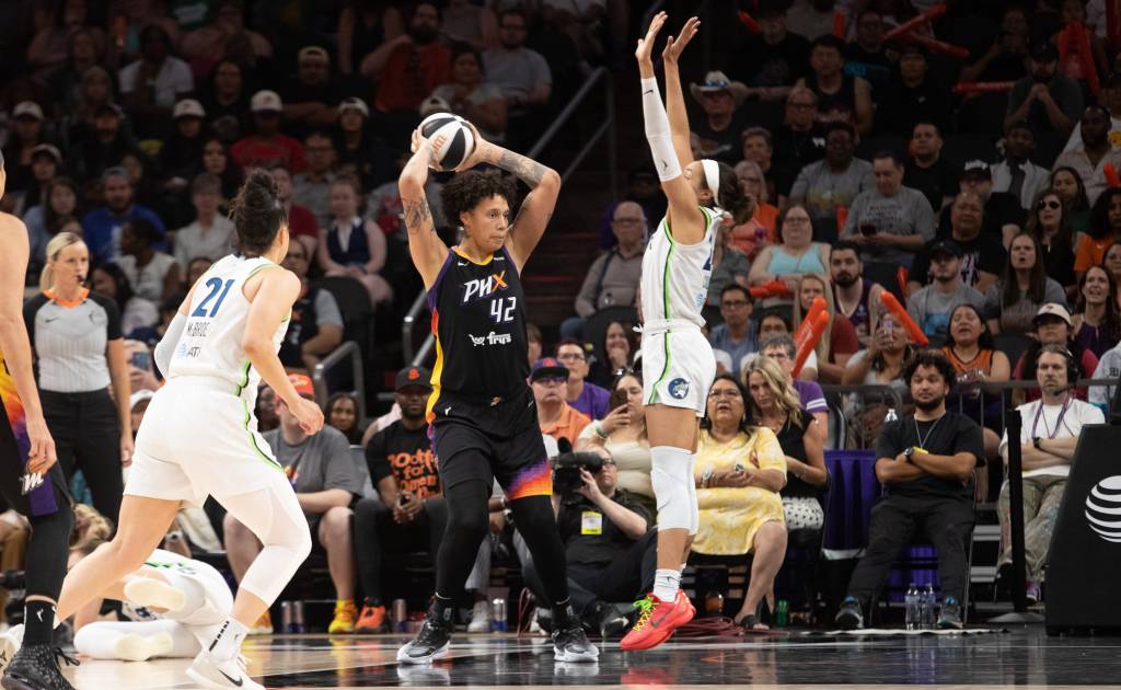 Brittney Griner holds the basketball above her head in a game against the Minnesota Lynx