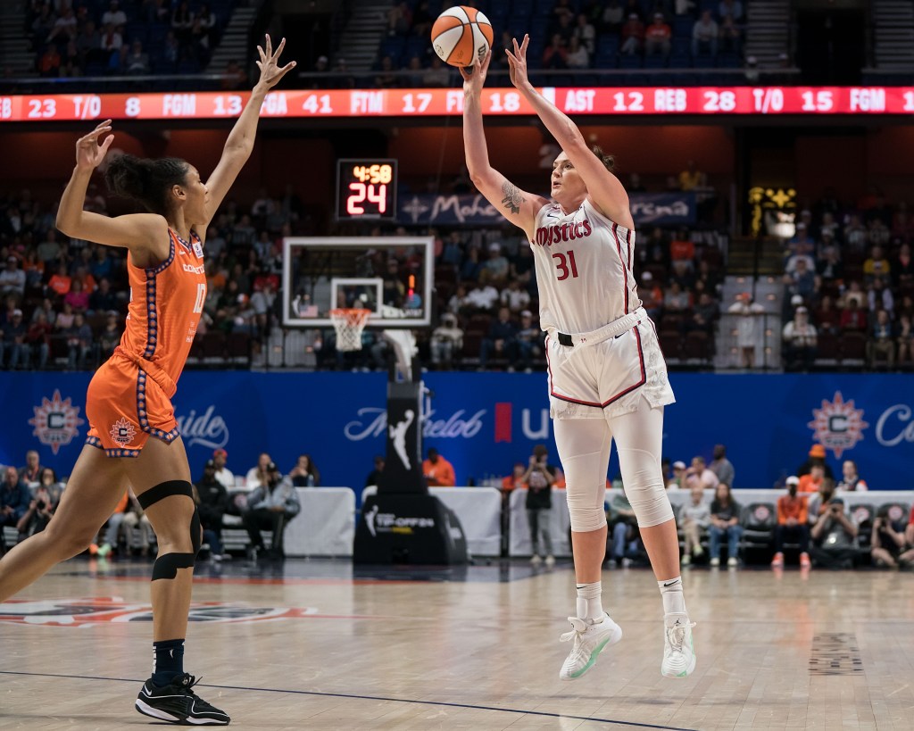 Washington Mystics center Stefanie Dolson shoots a 3-pointer as Connecticut Sun center Olivia Nelson-Ododa reaches her left hand up to contest it.