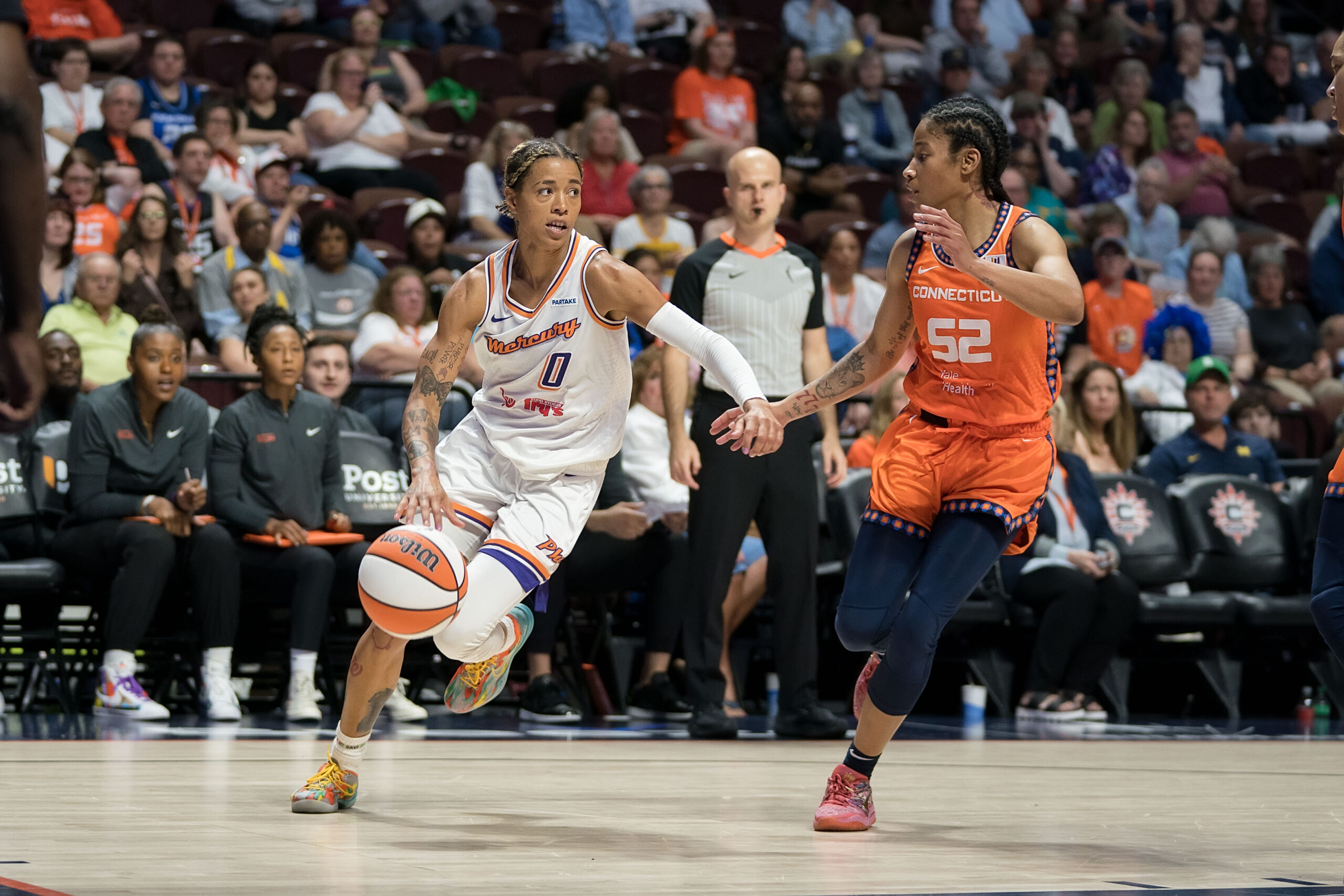 Phoenix Mercury guard Natasha Cloud (0) drives to the basket while defended by Connecticut Sun guard Tyasha Harris (52)