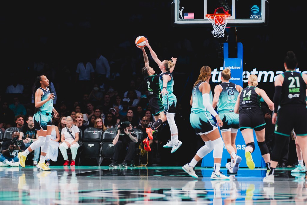 New York Liberty guard Courtney Vandersloot blocks Minnesota Lynx guard Natisha Hiedeman's layup attempt in the paint.