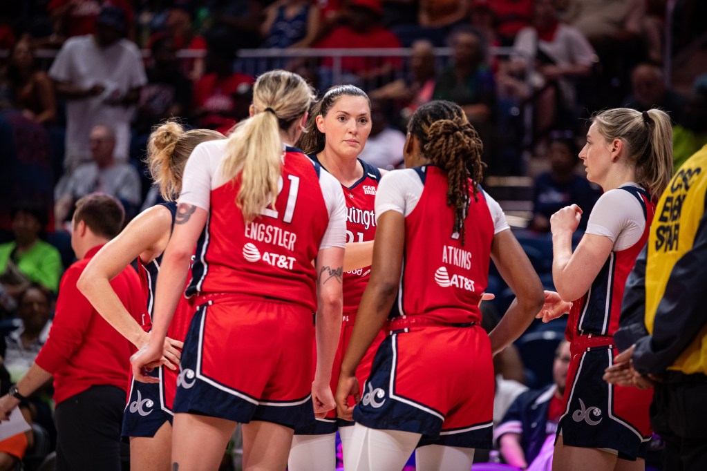 Washington Mystics center Stefanie Dolson talks to four of her teammates in a huddle.