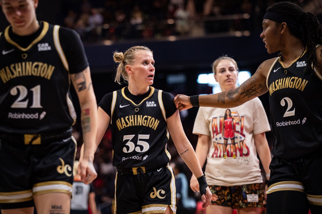 Washington Mystics forward Myisha Hines-Allen fist-bumps the shoulder of point guard Julie Vanloo as they walk off the court at halftime.