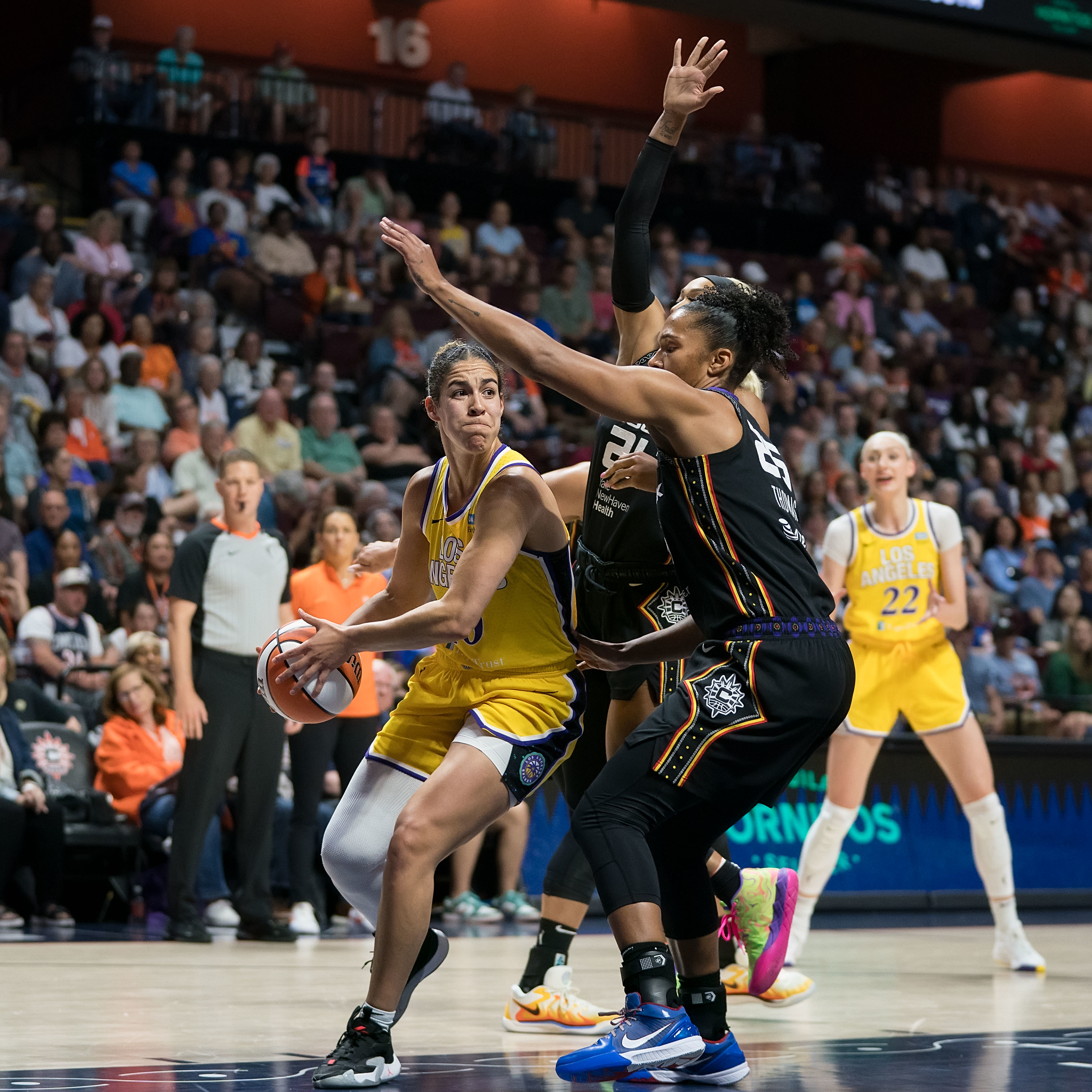 Kia Nurse drives to the basket against Connecticut Sun defense of Alyssa Thomas and Dijonai Carrington.