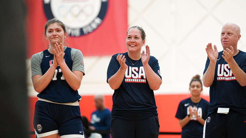 Meg Barber smiles and claps in a USA Basketball jersey