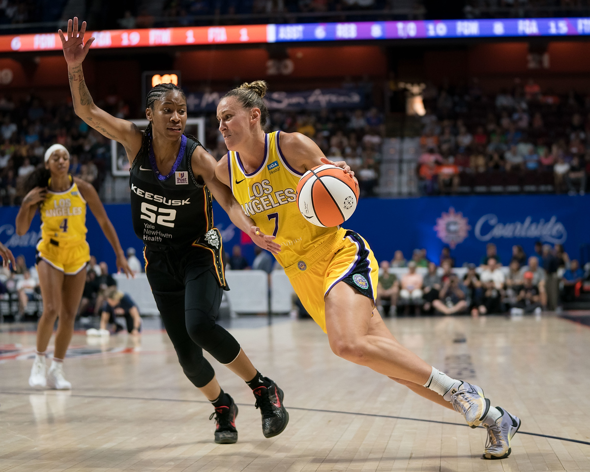 Los Angeles Sparks forward Stephanie Talbot has the ball at the top of her dribble as she drives against Connecticut Sun guard Tyasha Harris, who holds out an arm onto Talbot's side while trying to run side-by-side with her in a WNBA game
