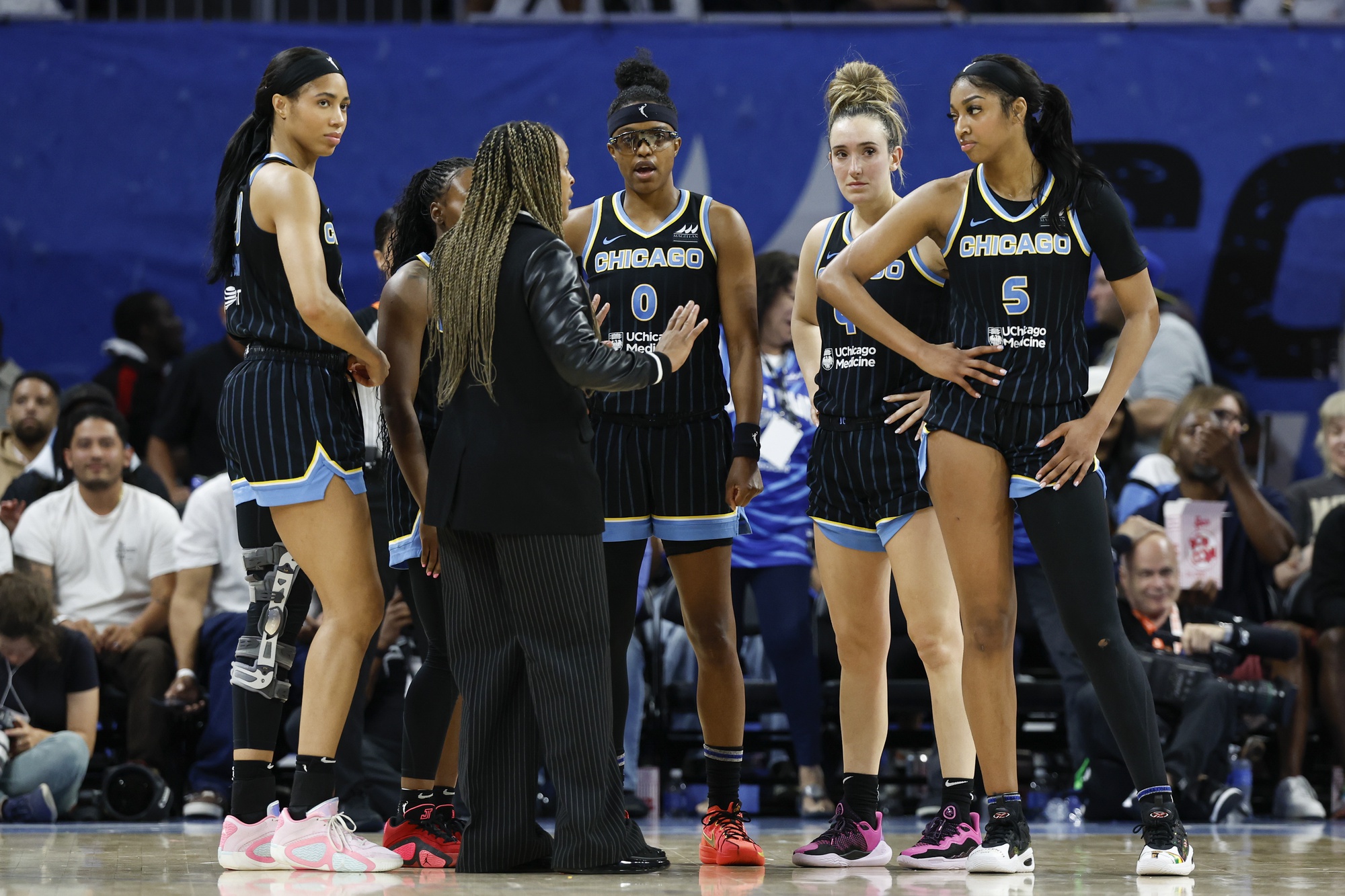 The Chicago Sky discuss things in a huddle with head coach Teresa Weatherspoon.
