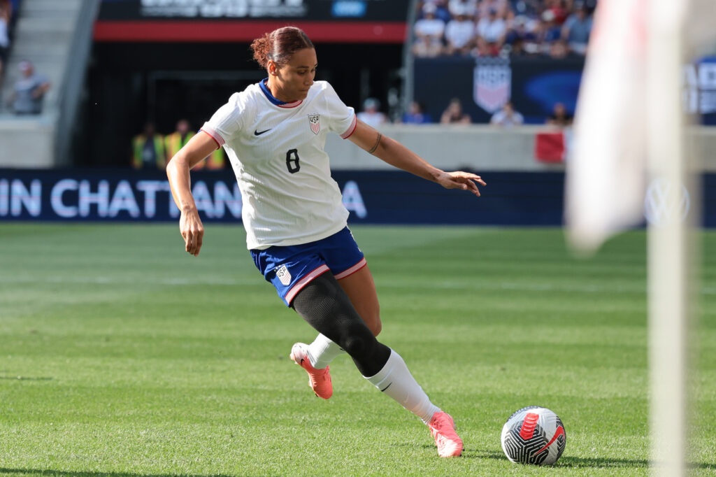 United States forward Lynn Williams, wearing a No. 8 USA jersey, kicks the ball