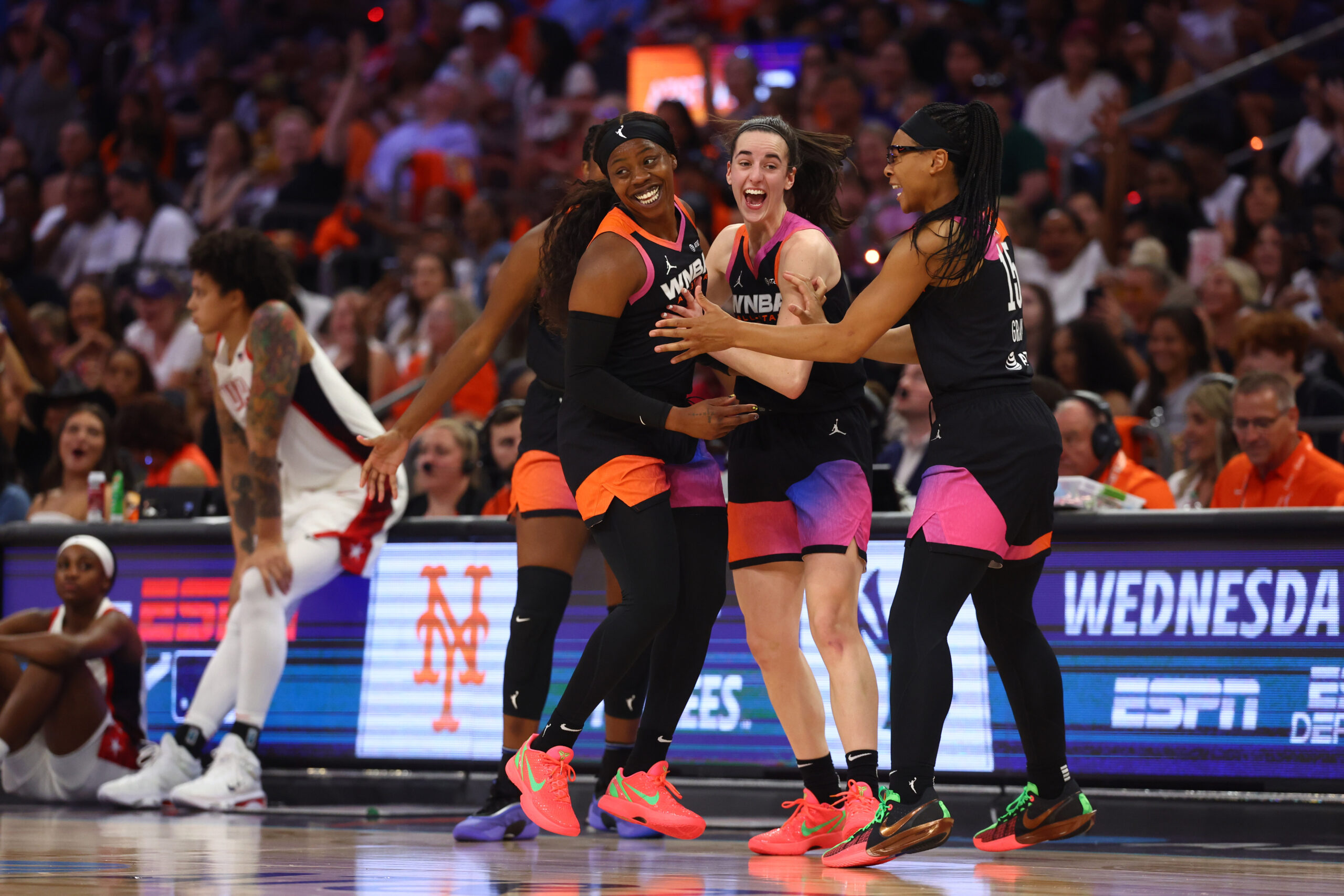 Arike Ogunbowale celebrates with teammates Caitlin Clark and Allisha Gray.