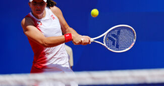 Iga Swiatek hits a backhand at the 2024 Olympic Games