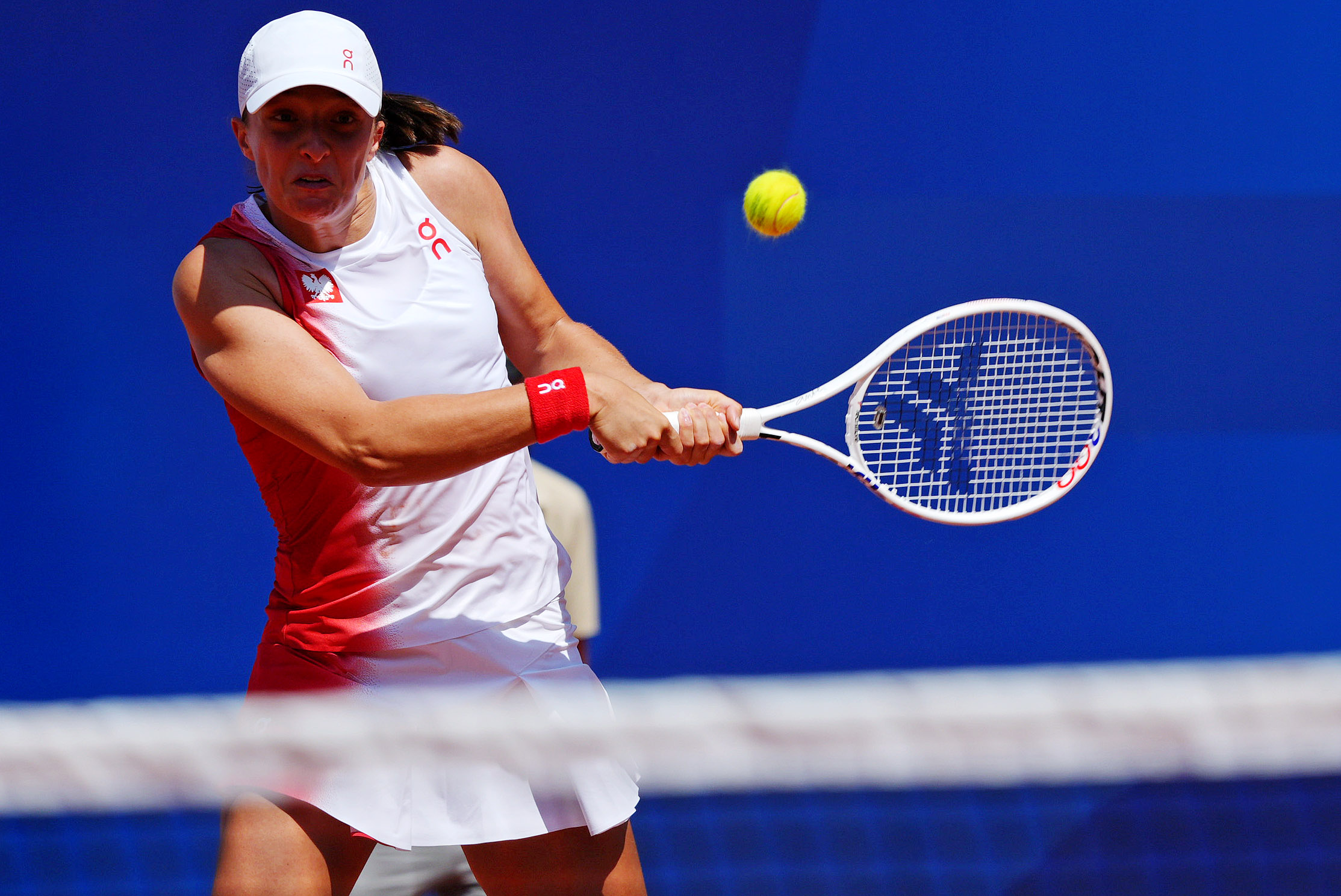 Iga Swiatek hits a backhand at the 2024 Olympic Games