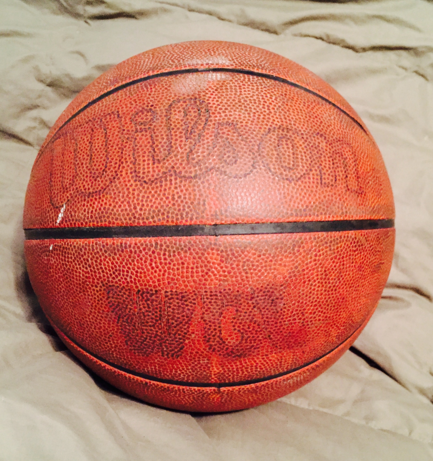 Worn basketball that reads "Wilson" on the top and "WBL" on the bottom.