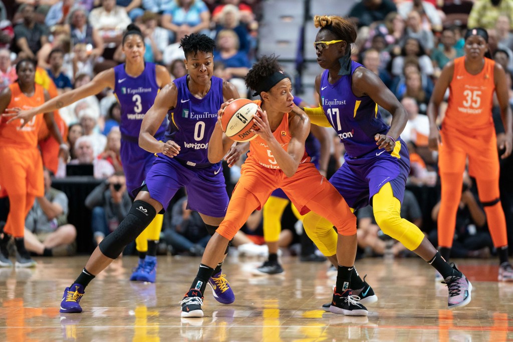 Los Angeles Sparks guard/forward Alana Beard eyes the ball that Connecticut Sun guard Jasmine Thomas is holding as Beard and Sparks forward Essence Carson double-team Thomas.
