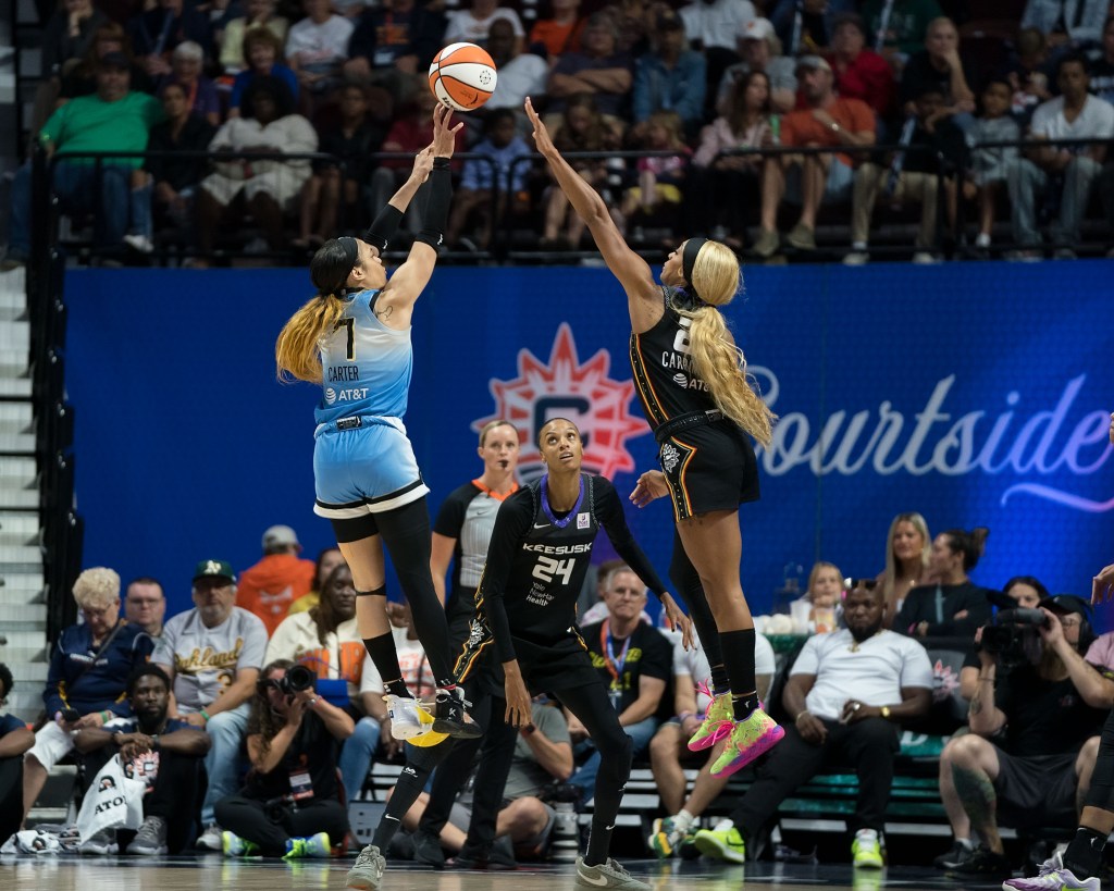 Chicago Sky guard Chennedy Carter  elevates while DiJonai Carrignton gets a hand up