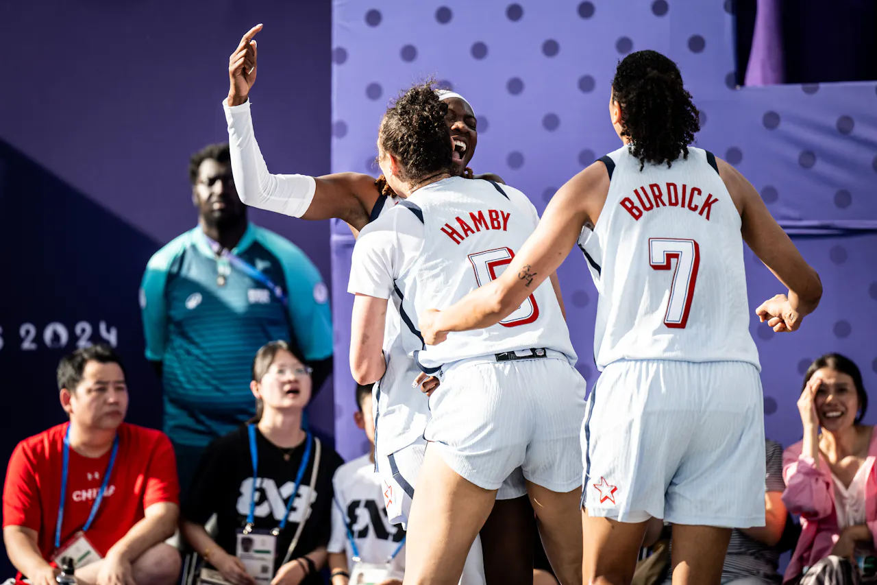 United States 3x3 players Dearica Hamby and Cierra Burdick celebrate with teammate Rhyne Howard after Howard made a game-winning shot.