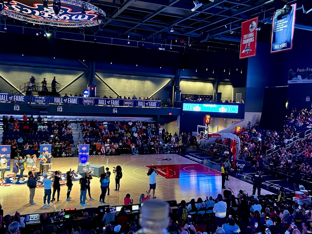 Former Washington Mystics guard/forward Alana Beard stands with general manager Mike Thibault, her family and her friends. She watches the new Mystics Hall of Fame banner with her name on it get unveiled in the rafters.