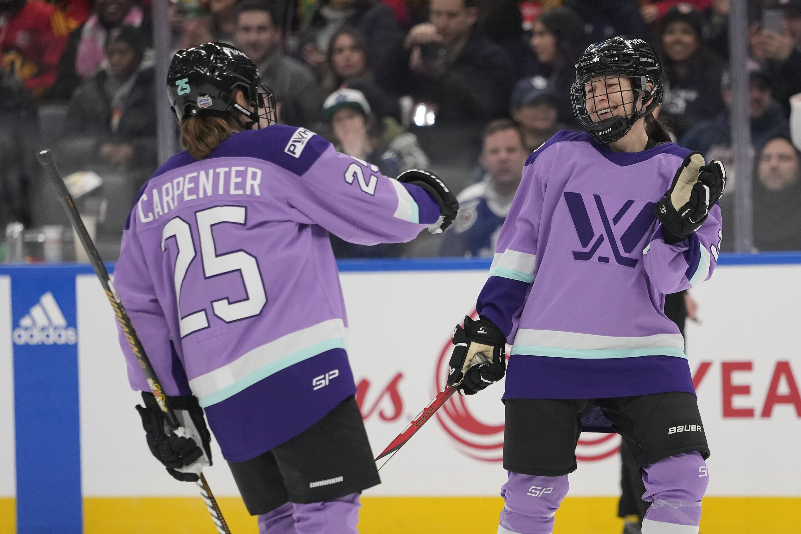 PWHL players motion towards eachother during the NHL 3x3 showcase