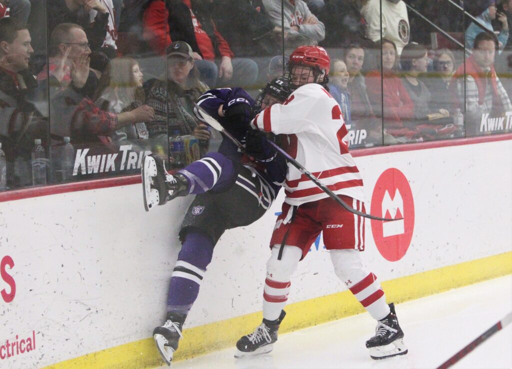 Wisconsin's Maddie Wheeler checks a player during NCAA women's hockey match