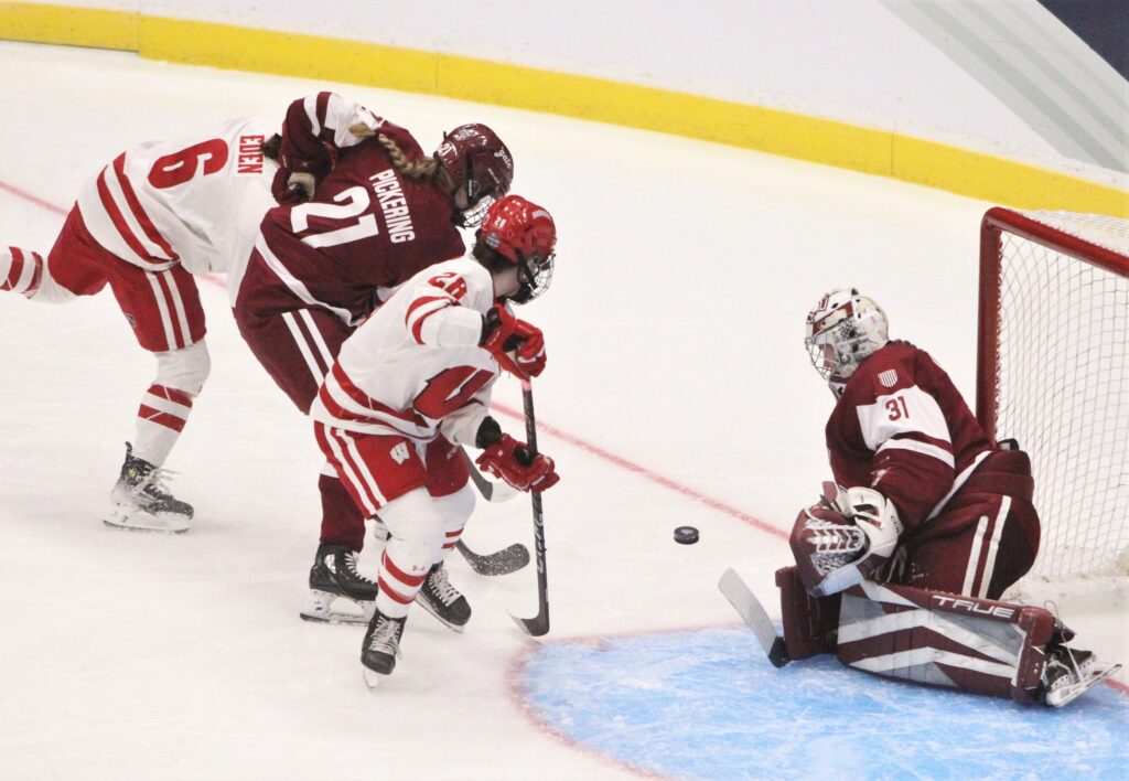 A shot from Wisconsin's Lacey Eden is stopped by Colgate goaltender Kayle Osborne