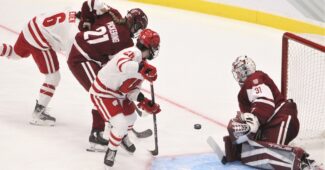 A shot from Wisconsin's Lacey Eden is stopped by Colgate goaltender Kayle Osborne