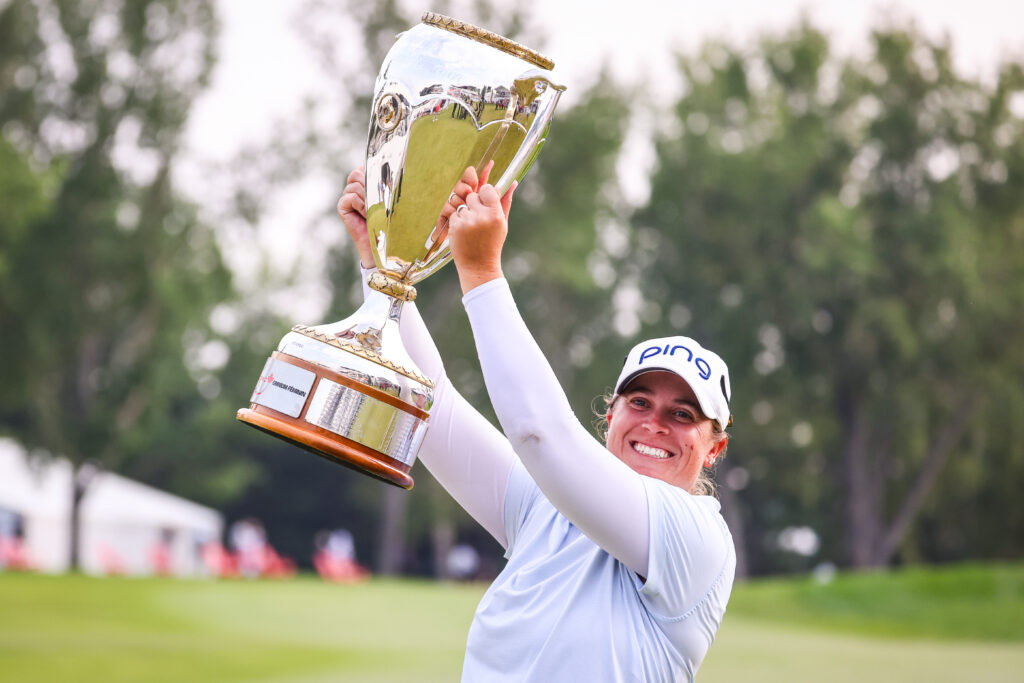 Lauren Coughlin celebrates with the winner's trophy during the final round of the CPKC Women's Open golf tournament.