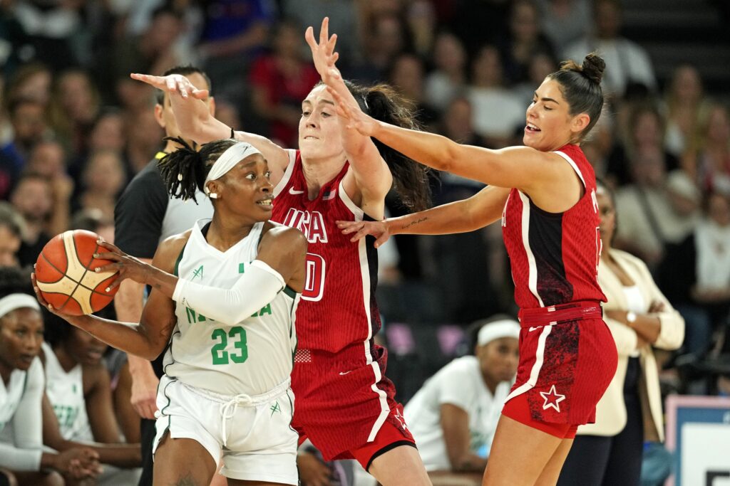 Aug 7, 2024; Paris, France; Nigeria point guard Ezinne Kalu (23) handles the ball against United States power forward Breanna Stewart (10) and guard Kelsey Plum (5) in the women’s basketball quarterfinals during the Paris 2024 Olympic Summer Games at Accor Arena. Mandatory Credit: Kyle Terada-USA TODAY Sports