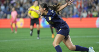 Seattle Reign FC forward Emeri Adames runs with outspread arms to celebrate a goal
