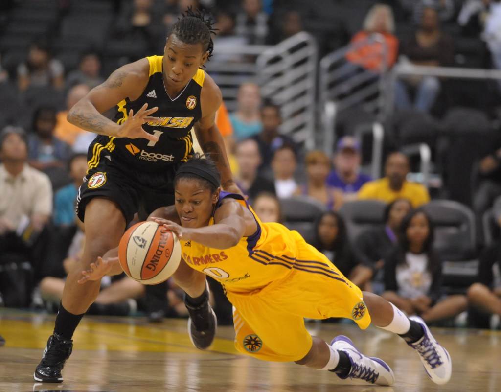 Los Angeles Sparks guard/forward Alana Beard dives and gets her left hand on a loose ball. Tulsa Shock guard Riquna Williams is behind her, also vying for the ball.