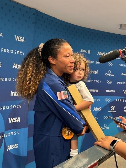 U.S. defender Casey Kruger holds her child in her arms in the press area