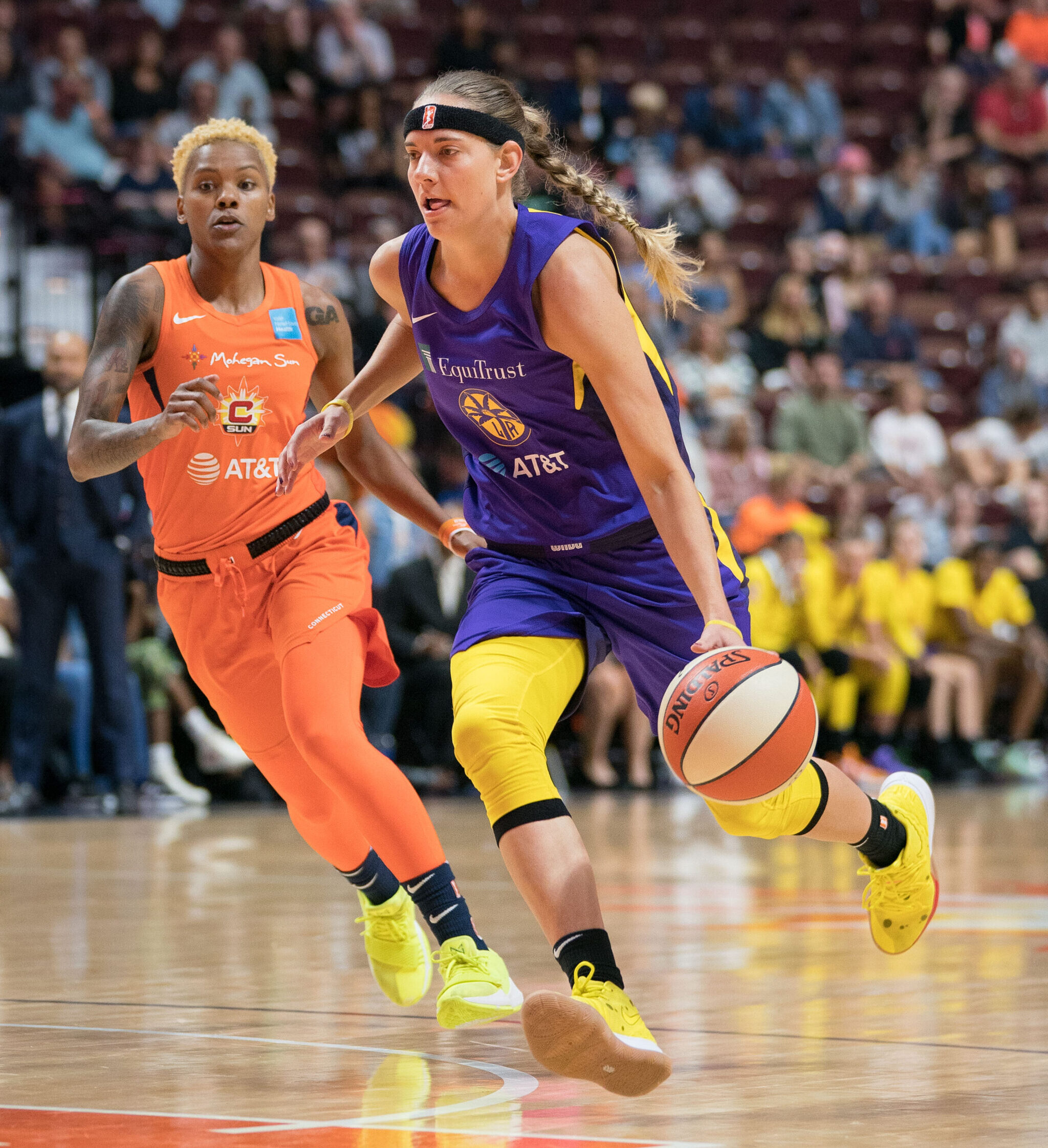 Los Angeles Sparks guard Sydney Wiese dribbles the ball with her left hand, attacking the lane. A Connecticut Sun defender trails the play.
