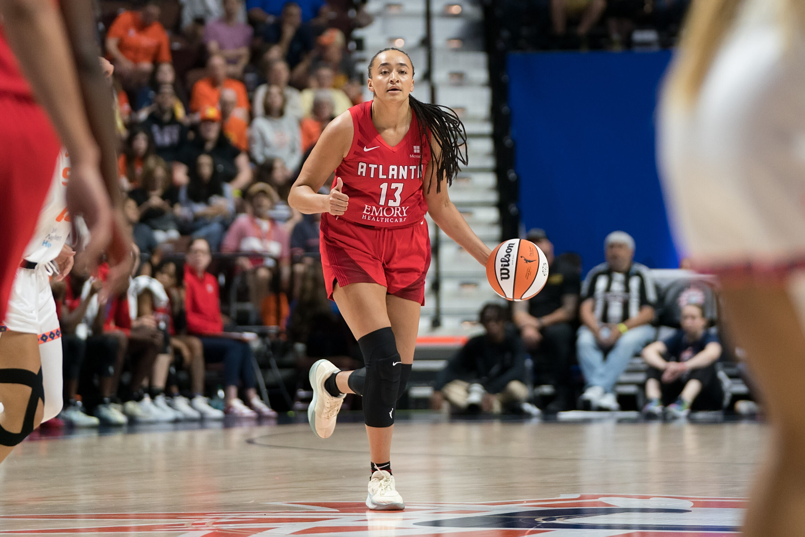 Haley Jones calls out a play for the Atlanta Dream, as she dribbles the ball up the floor.
