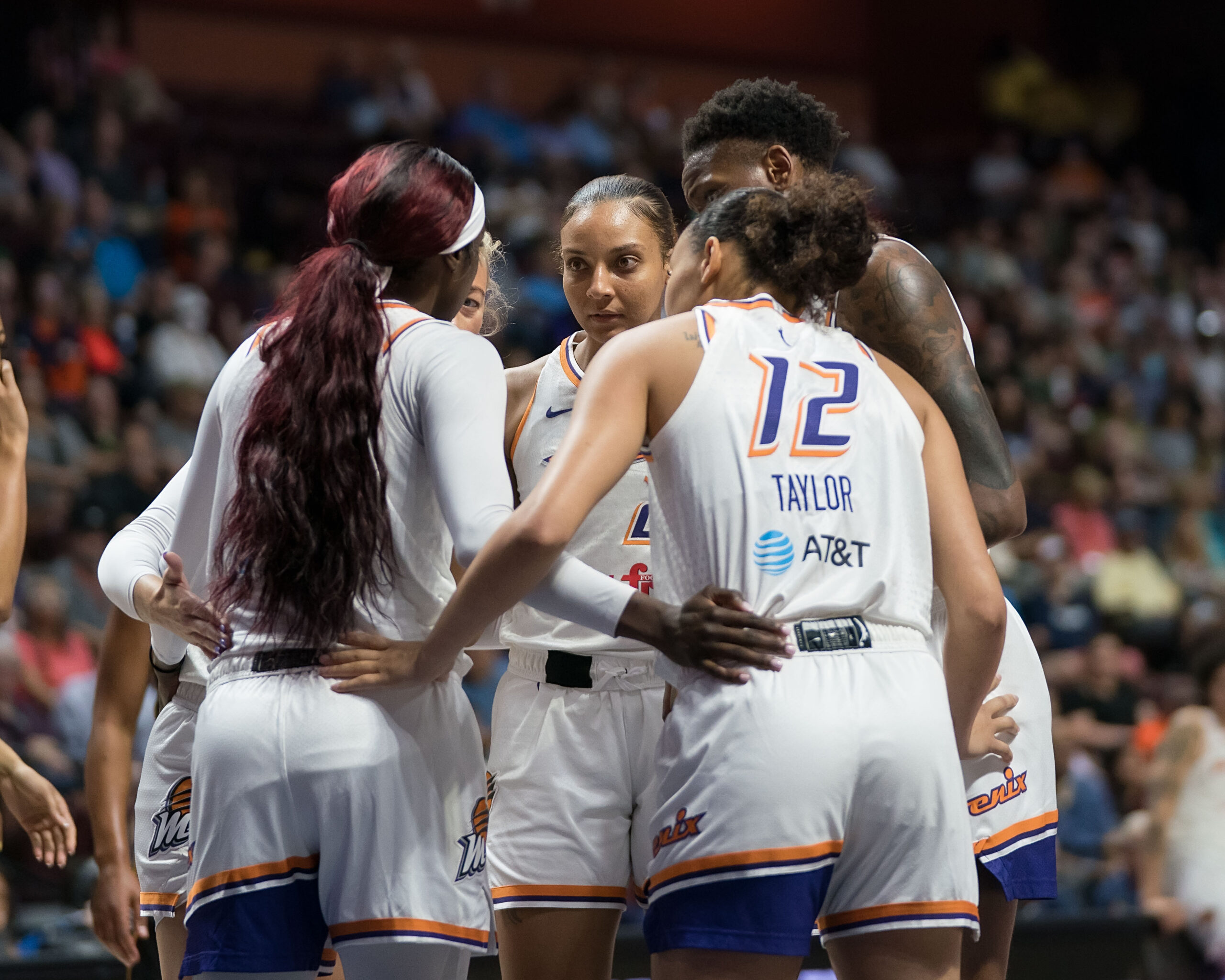 The Phoenix Mercury huddle with their arms around each other
