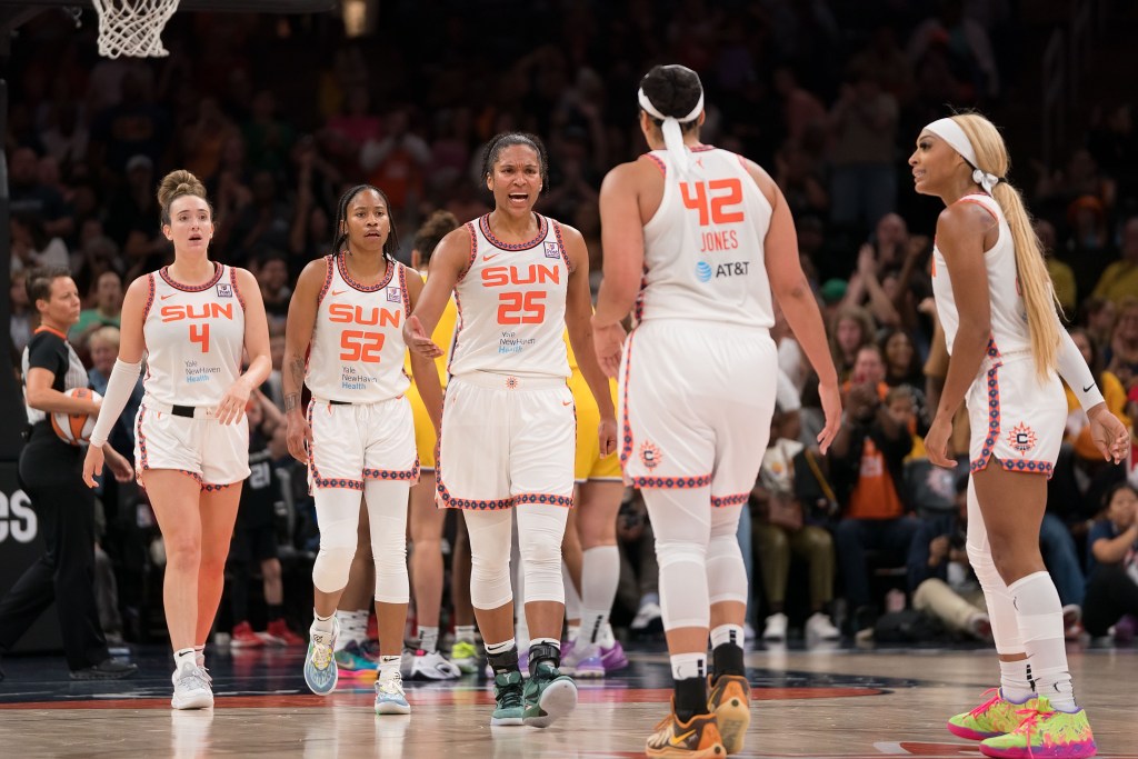 Brionna Jones, back to the camera, is pictured approaching her Sun teammates while a member of the Sun