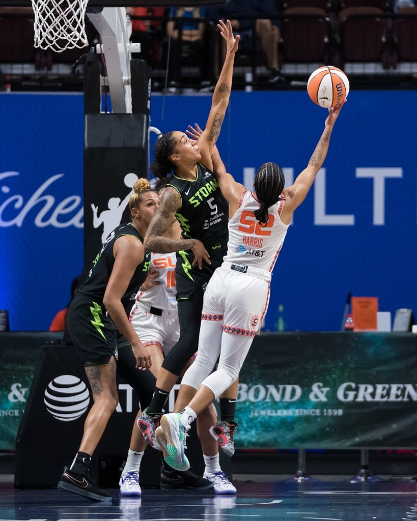 Connecticut Sun guard Tyasha Harris attempts a right-handed layup as Seattle Storm forward Gabby Williams leaps to try to contest it.