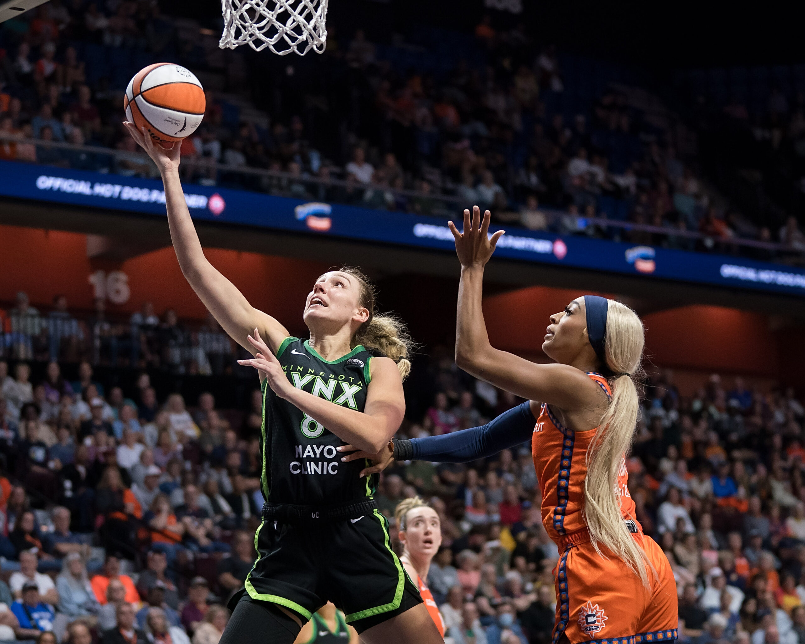 Minnesota Lynx forward Alanna Smith shoots a right-handed layup. Connecticut Sun guard DiJonai Carrington tries to defend but is arriving too late to contest the shot.