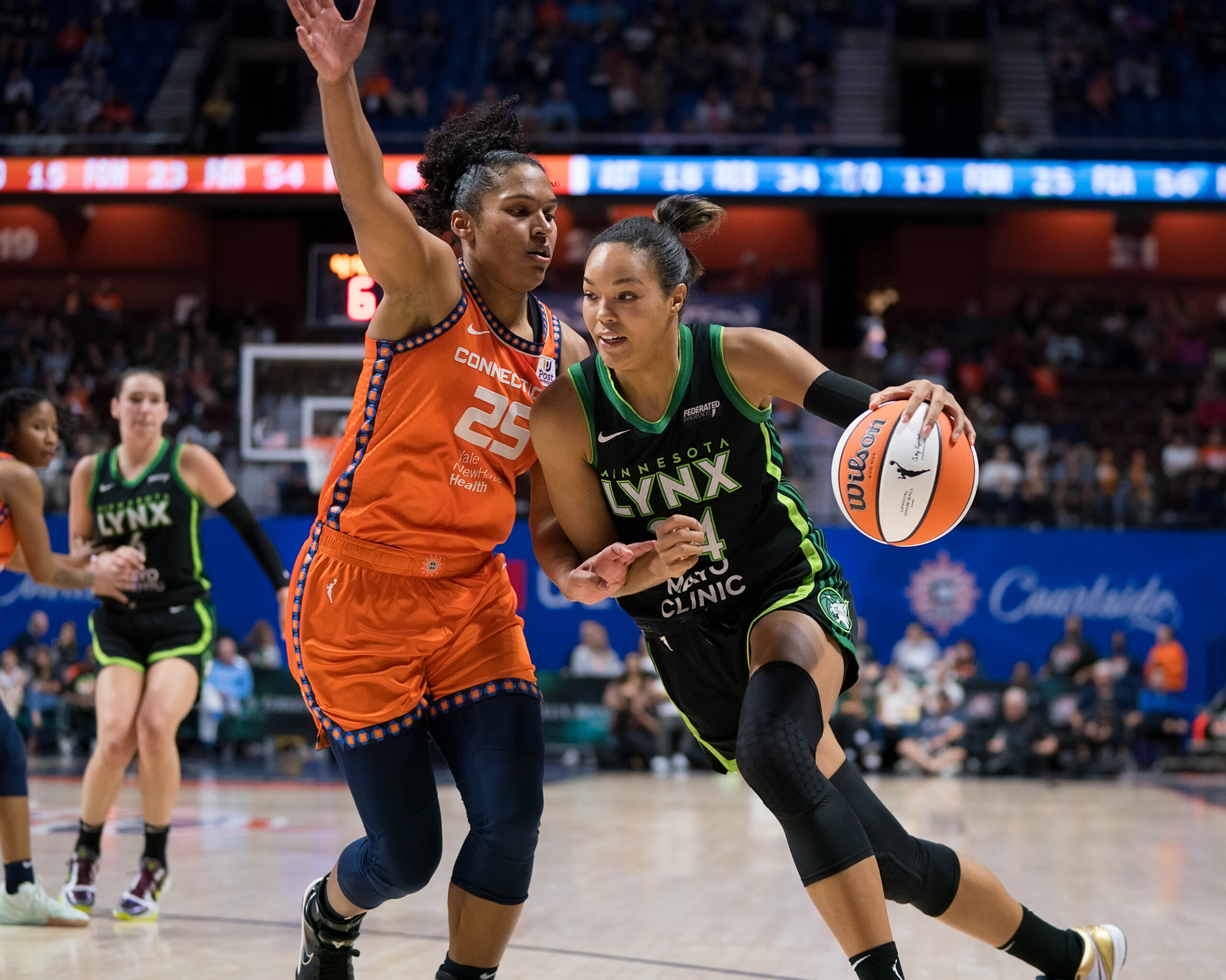 Minnesota Lynx forward Napheesa Collier drives to the hoop with her left hand as Connecticut Sun forward Alyssa Thomas tries to slide over and cut her off.