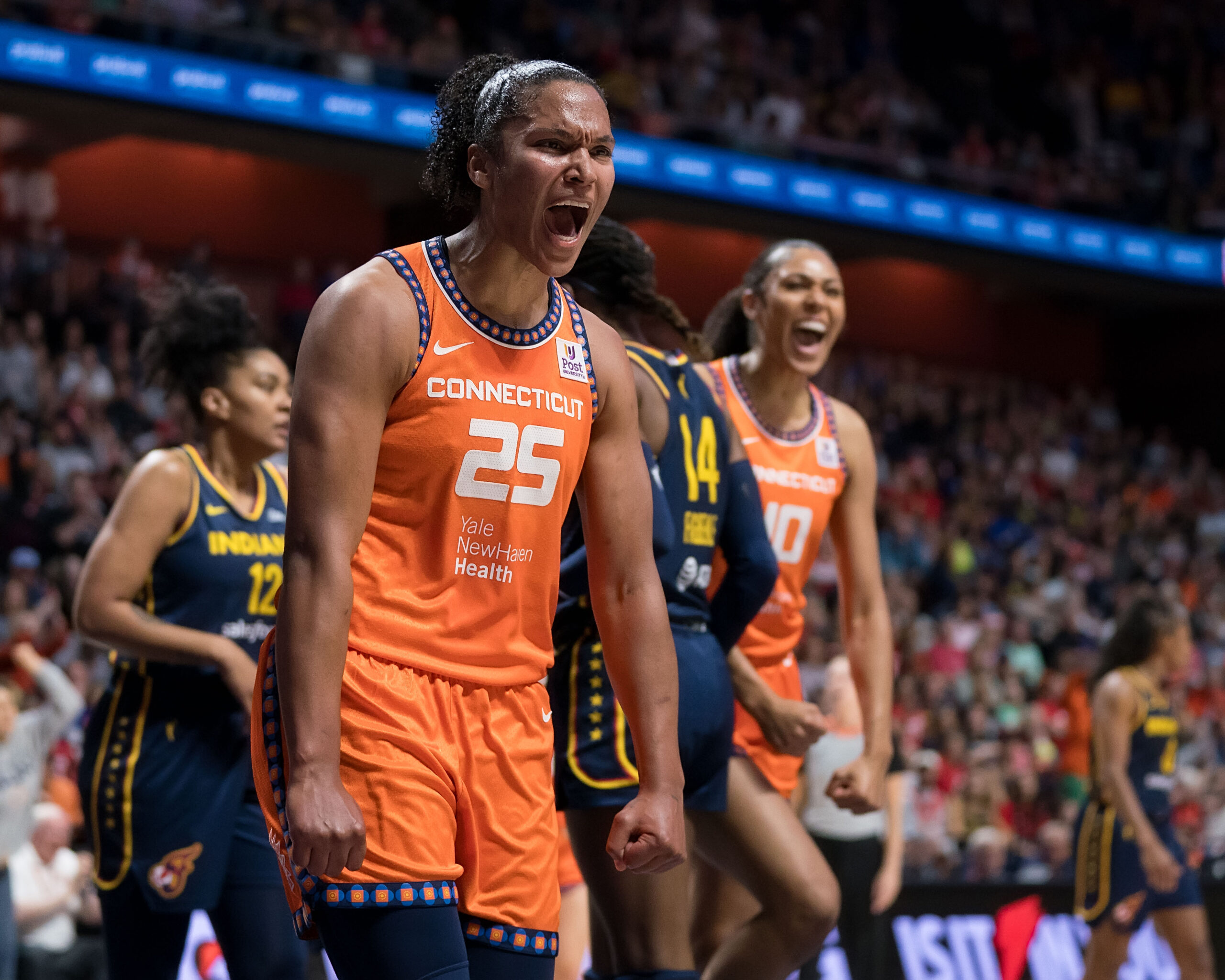 Connecticut Sun forward Alyssa Thomas and center Olivia Nelson-Ododa clench their fists and yell in celebration during a playoff game against the Indiana Fever.